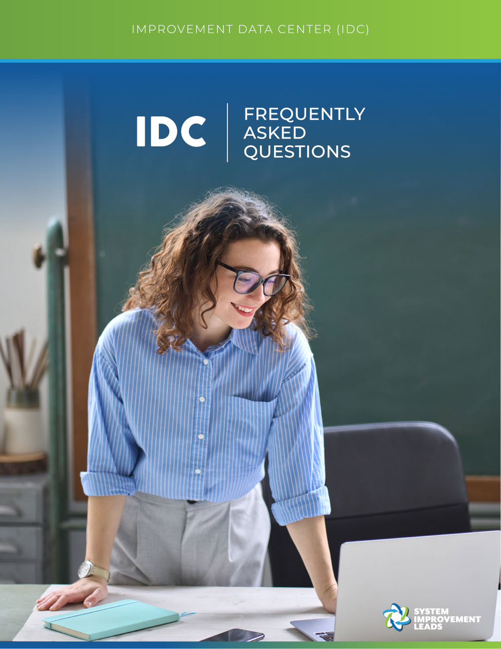 an educator smiling and looking at their laptop